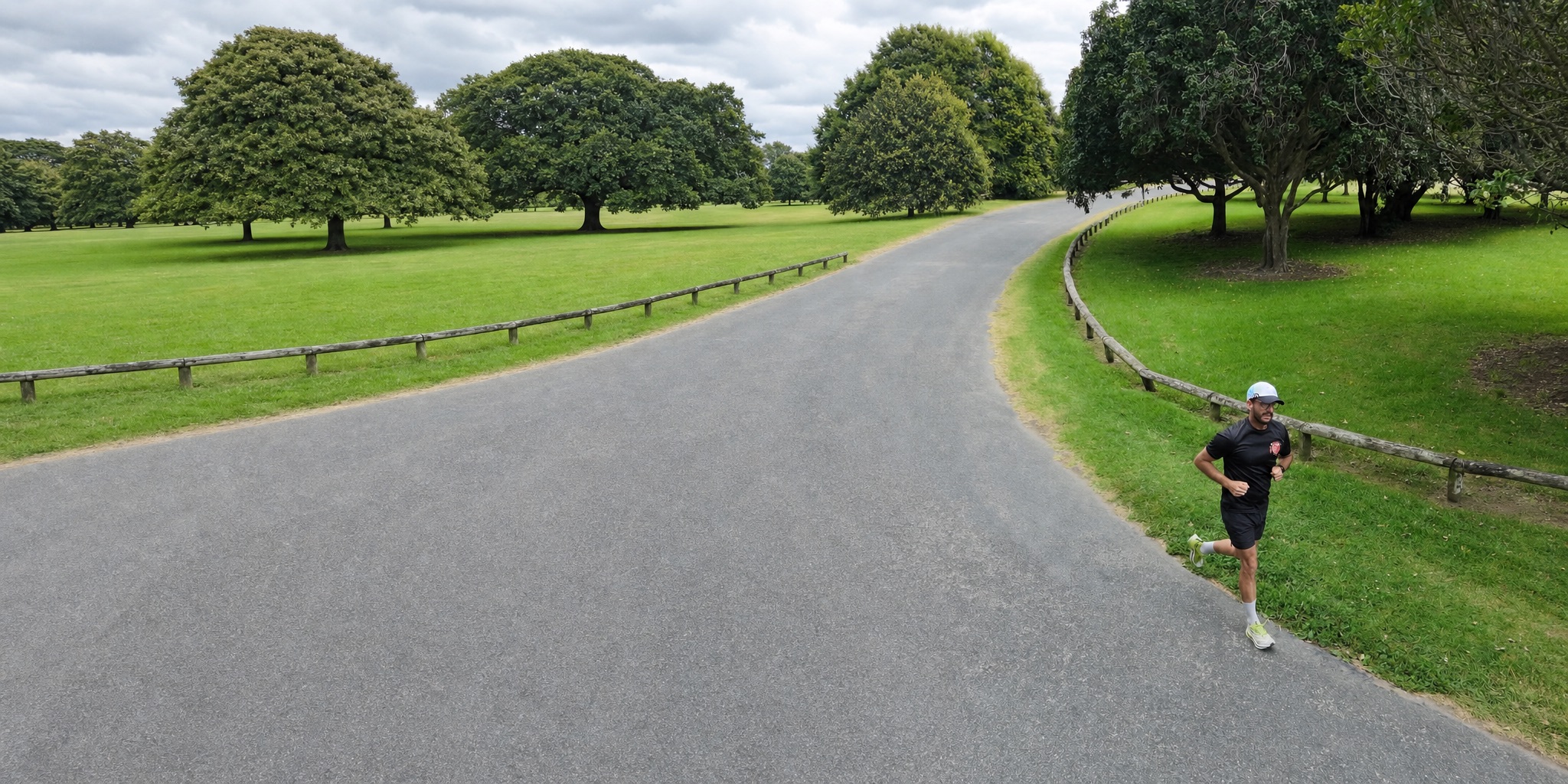 Matthew running along a tree-lined park path